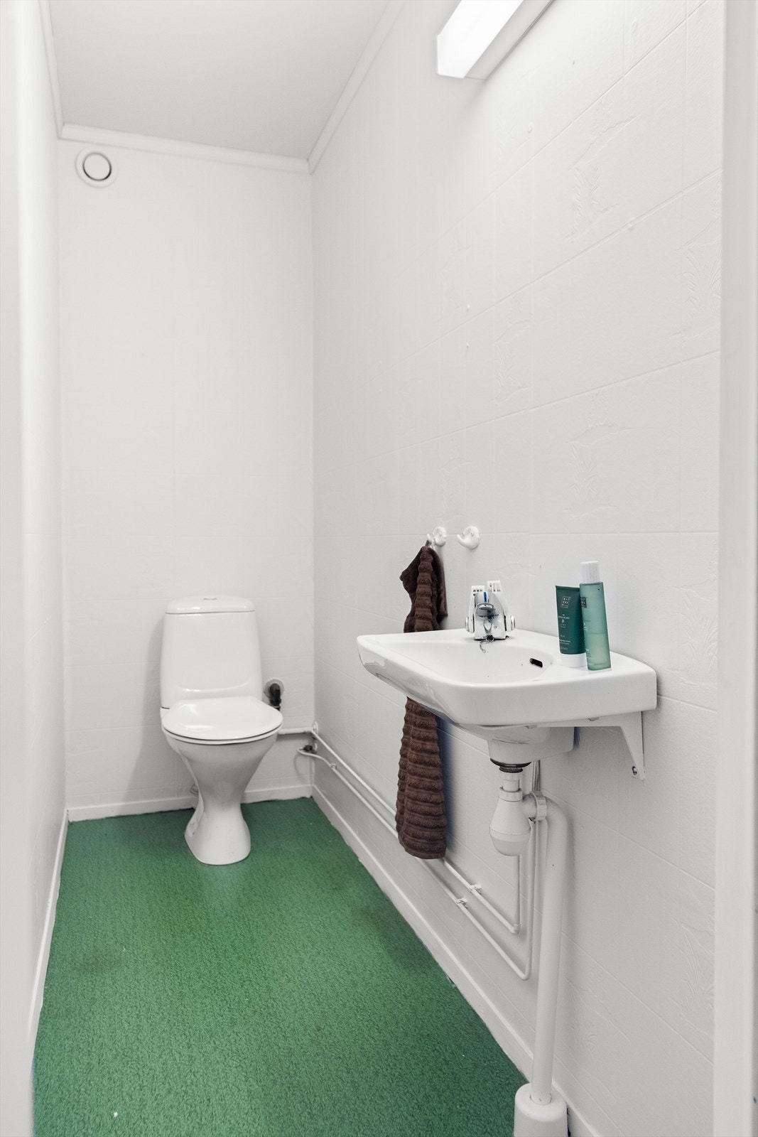 Vegg i vegg med badet ligger et separat toalettrom. Rommet er av eldre standard, og er innredet med servant og vannklosett. Oppussing må påregnes. Galleribilde