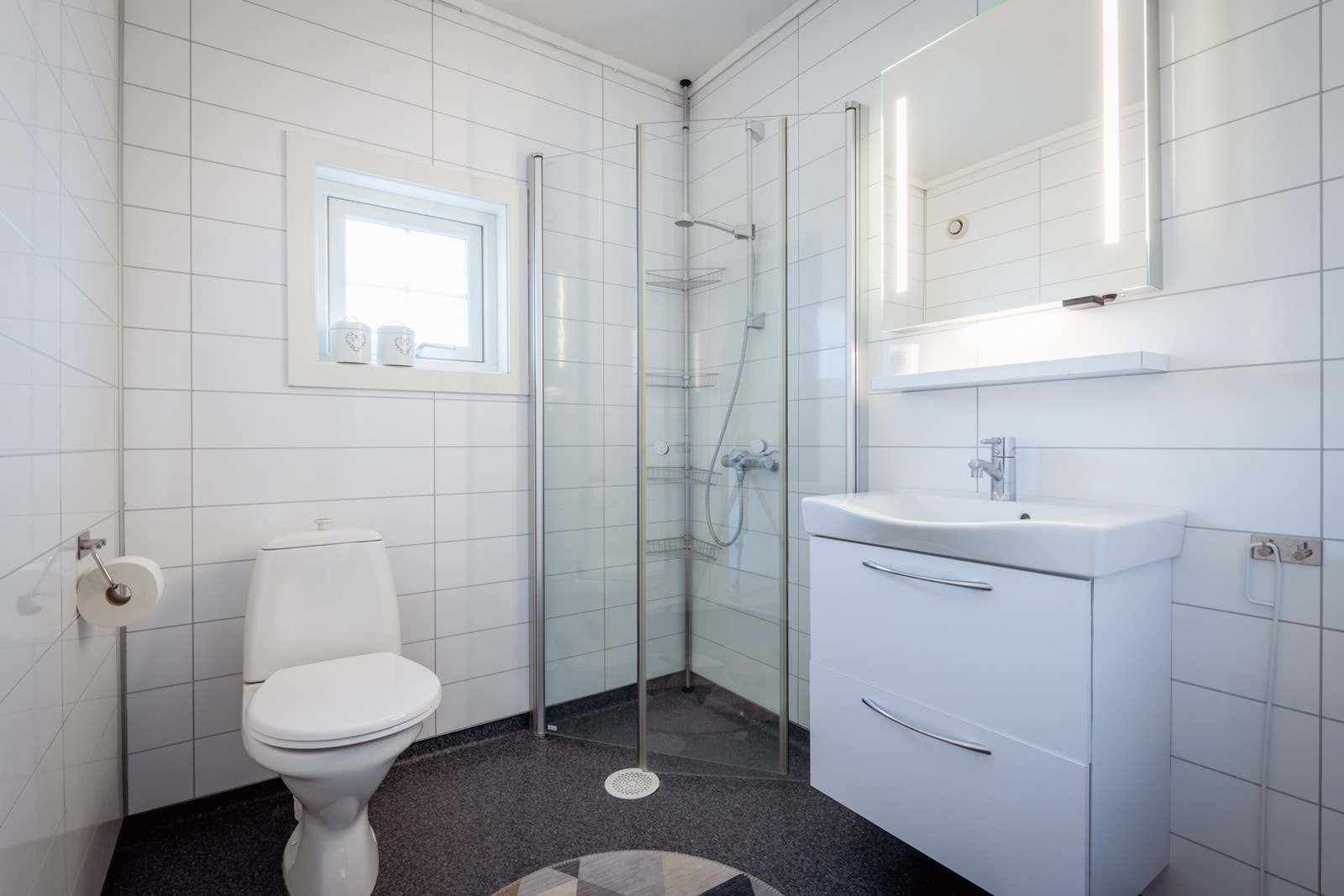Bad i 2 etasje med wc, enkel servant og innfelbart dusjhjørne. Skuffer under servanten til oppbevaring. Galleribilde
