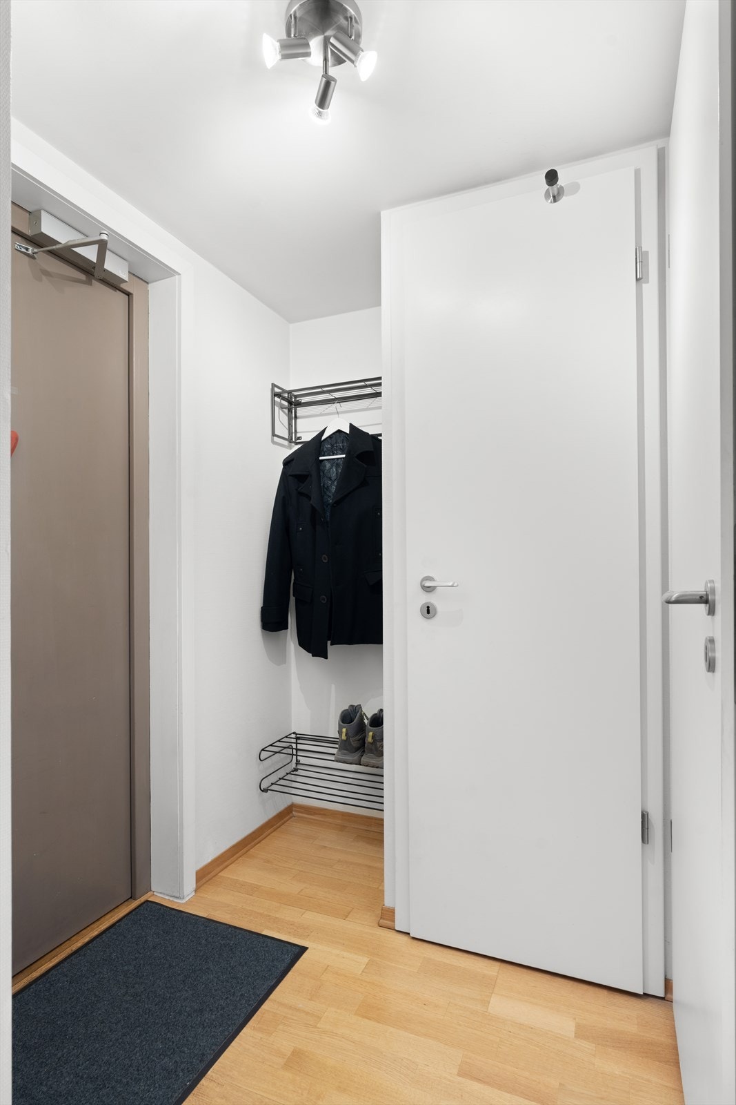 Velkommen inn i en lys og praktisk entré med dørcalling og plass til oppbevaring av yttertøy og sko. Galleribilde