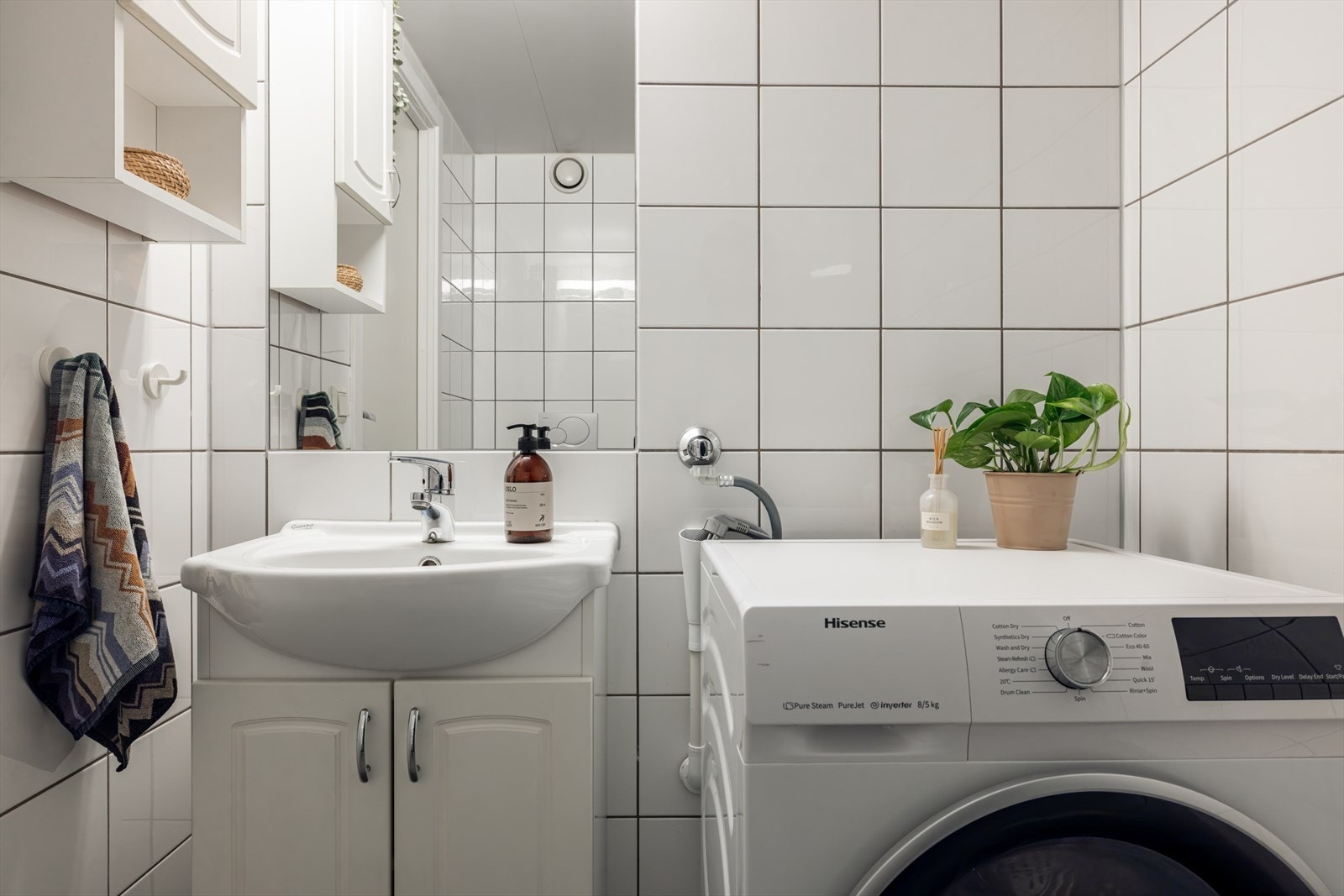 På baderommet finner du en dusjnisje med innfellbare dusjdører, vegghengt toalett, servant på underskap og opplegg for vaskemaskin. Galleribilde