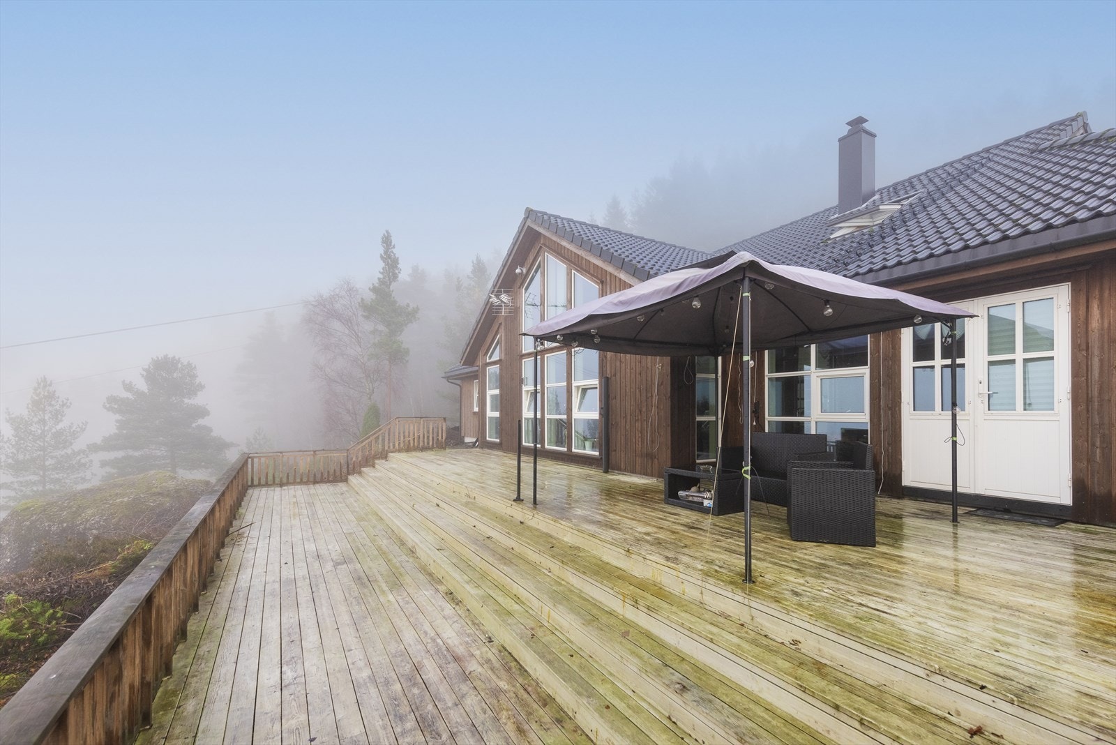 På fremsiden av boligen er det en stor terrasse med god plass til hagemøblement. Galleribilde