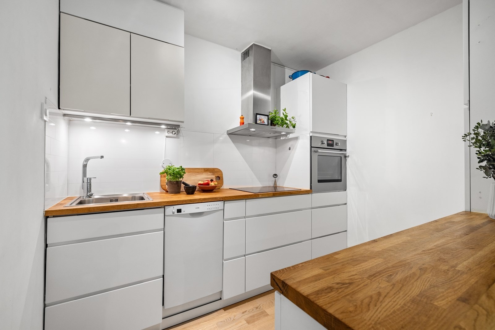 Med en åpen stue- og kjøkkenløsning får du en god romfølelse, og fra kjøkkenet kan du holde samtalen i gang mens du disker opp et måltid. Galleribilde