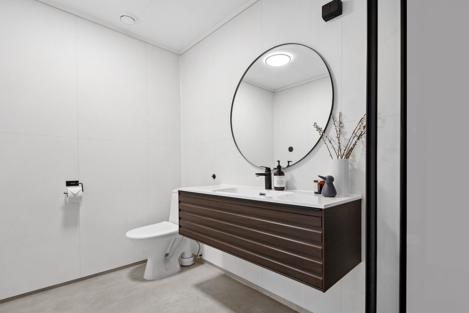 Baderommet har baderomsplater på vegg og belegg på gulvet. Galleribilde