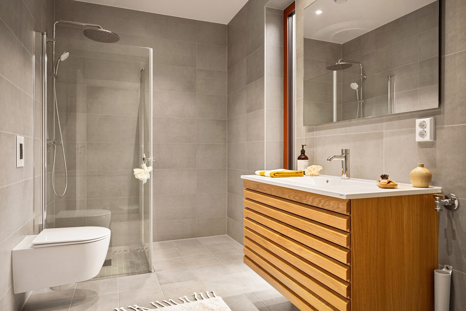 Stilrent og lekkert bad med innredning "Nordic Spirit" i natur eik fra HTH, med heldekkende hvit servantplate og lekkert ettgreps servantbatteri fra Grohe. Opplegg for vaskemaskin. Galleribilde