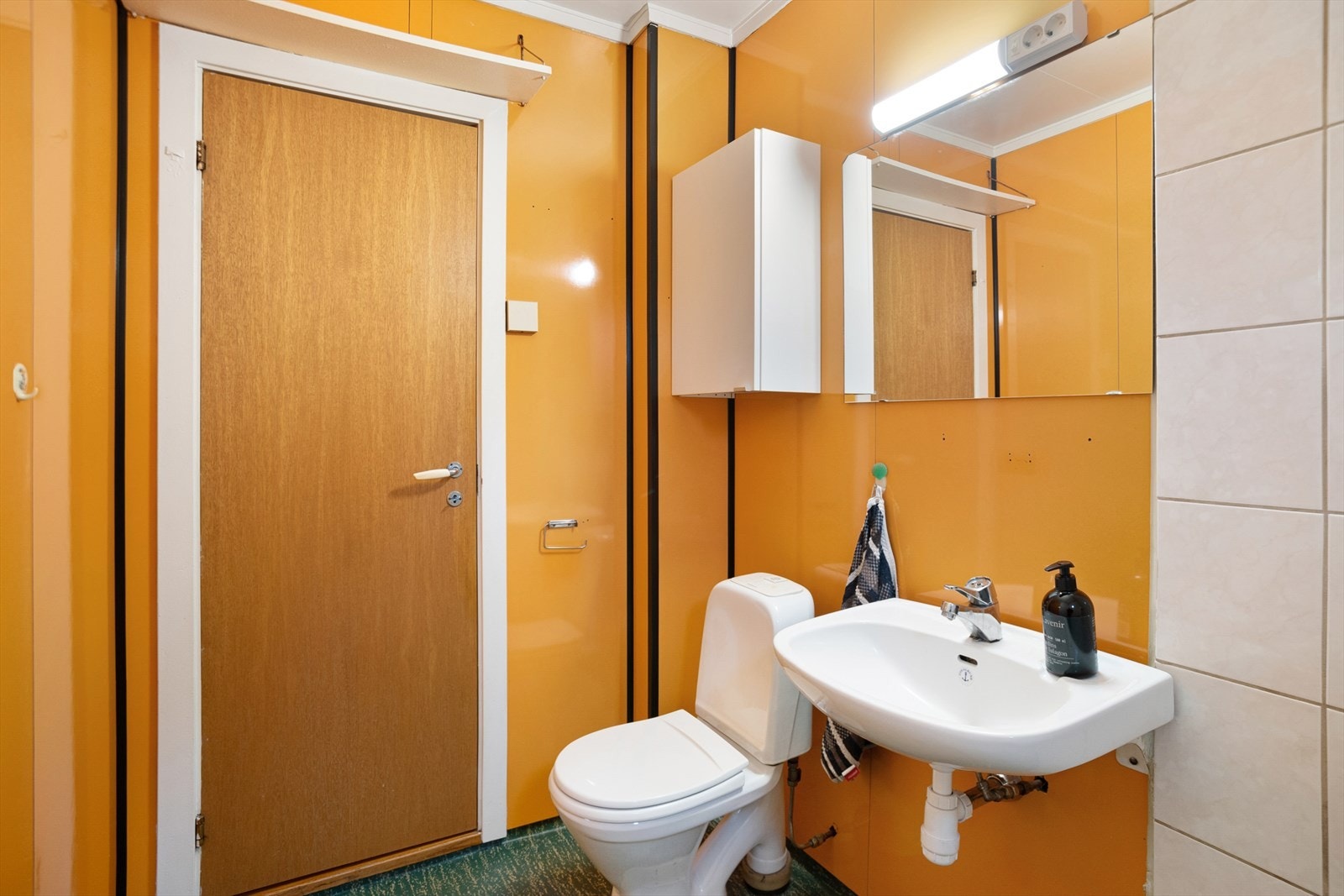 Eldre baderom modent for renovering. Badet er utstyrt med vask, dusjhjørne og toalett. Galleribilde