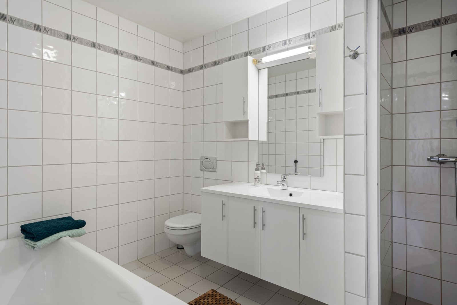 Flislagt bad med både badekar og dusjnisje Galleribilde