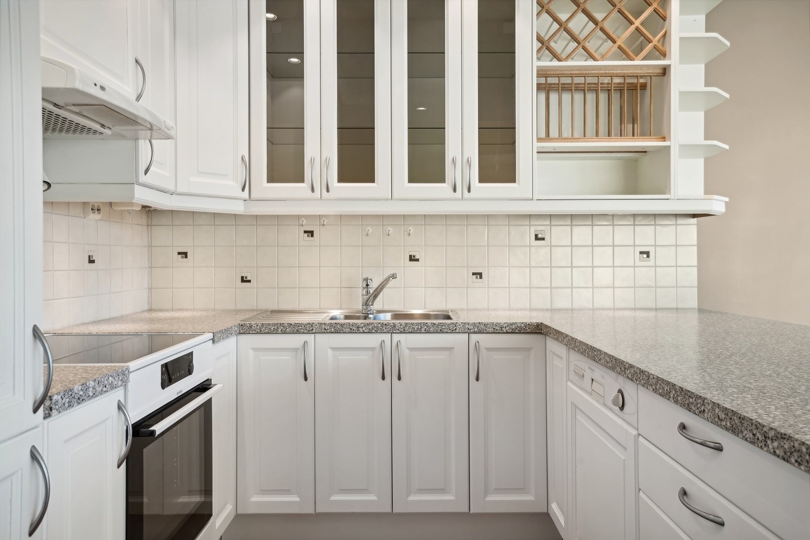 Innholdsrikt kjøkken med kjøl/ fryseskap, oppvaskmaskin og komfyr Galleribilde