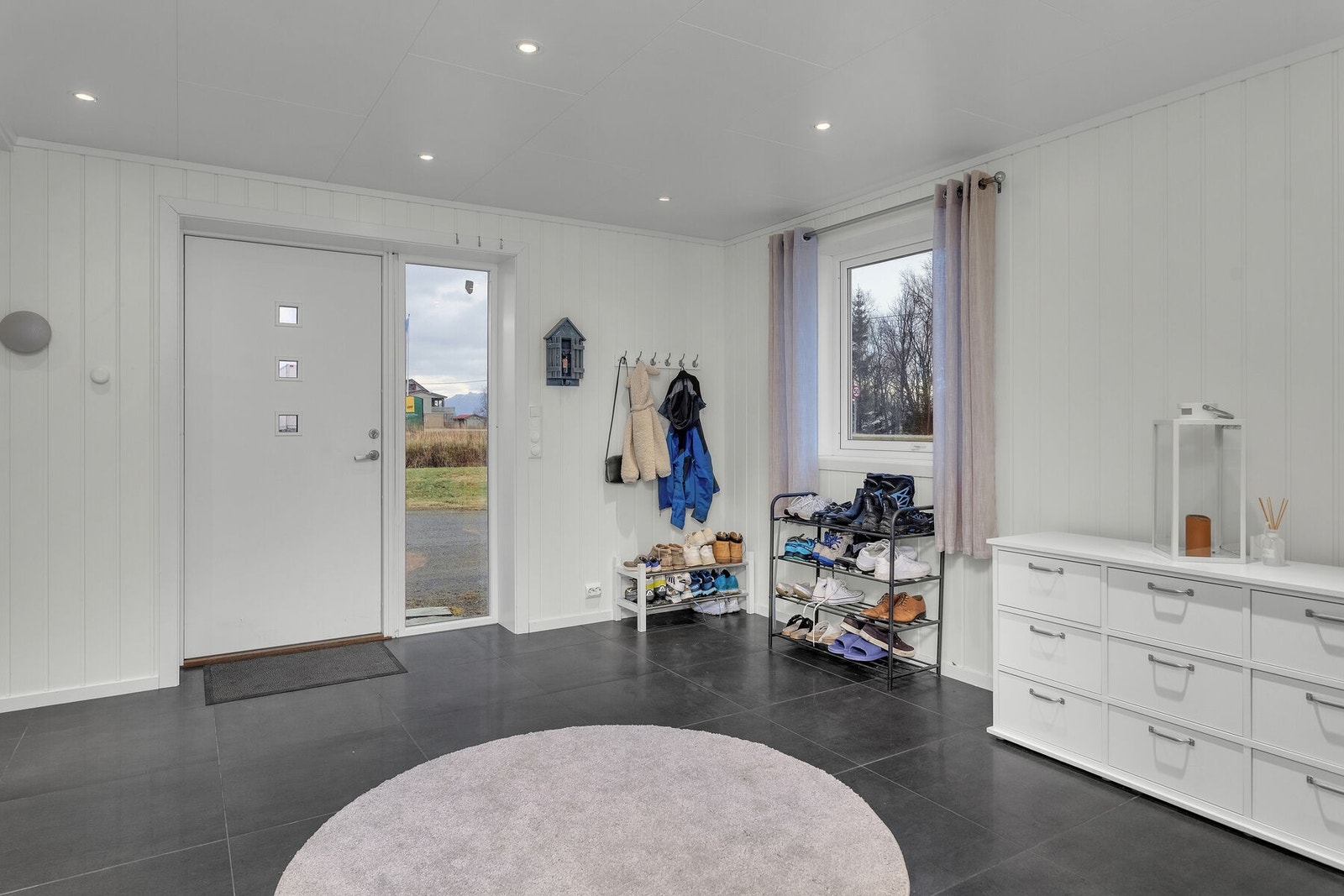 Romslig entré med fliser på gulvet og spotter i taket. Galleribilde