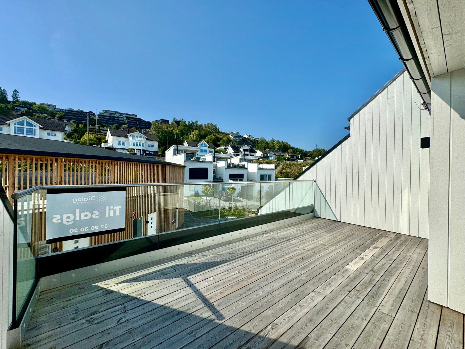 Tilbaketrukket vestvendt takterrasse utenfor loftsstuen med glass i rekkverk Galleribilde