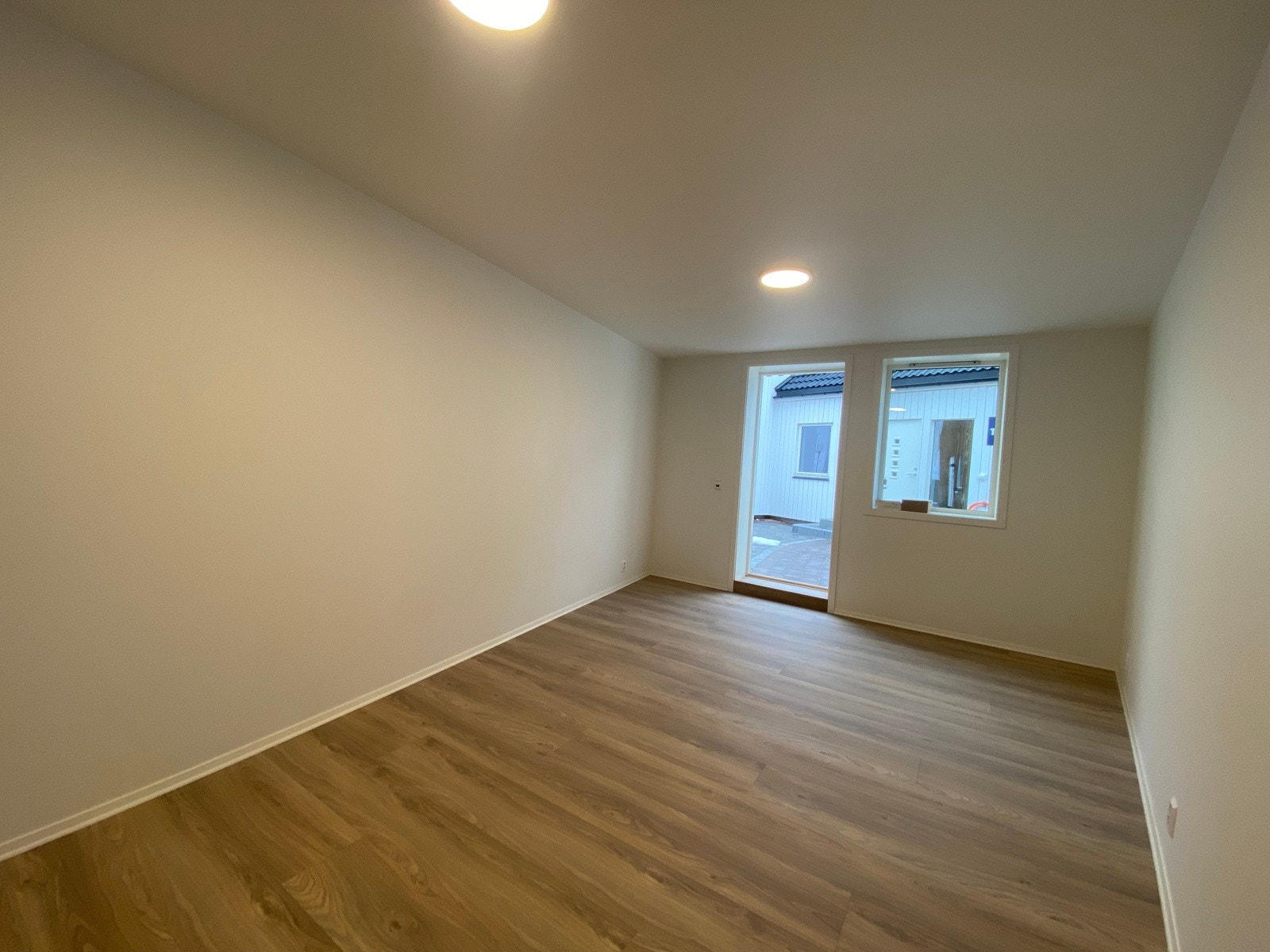 Stor innredet bod ligger plassert under carporten og er på hele 14 kvm | innredet med laminatgulv og malte vegger, vindu og varmekabler Galleribilde