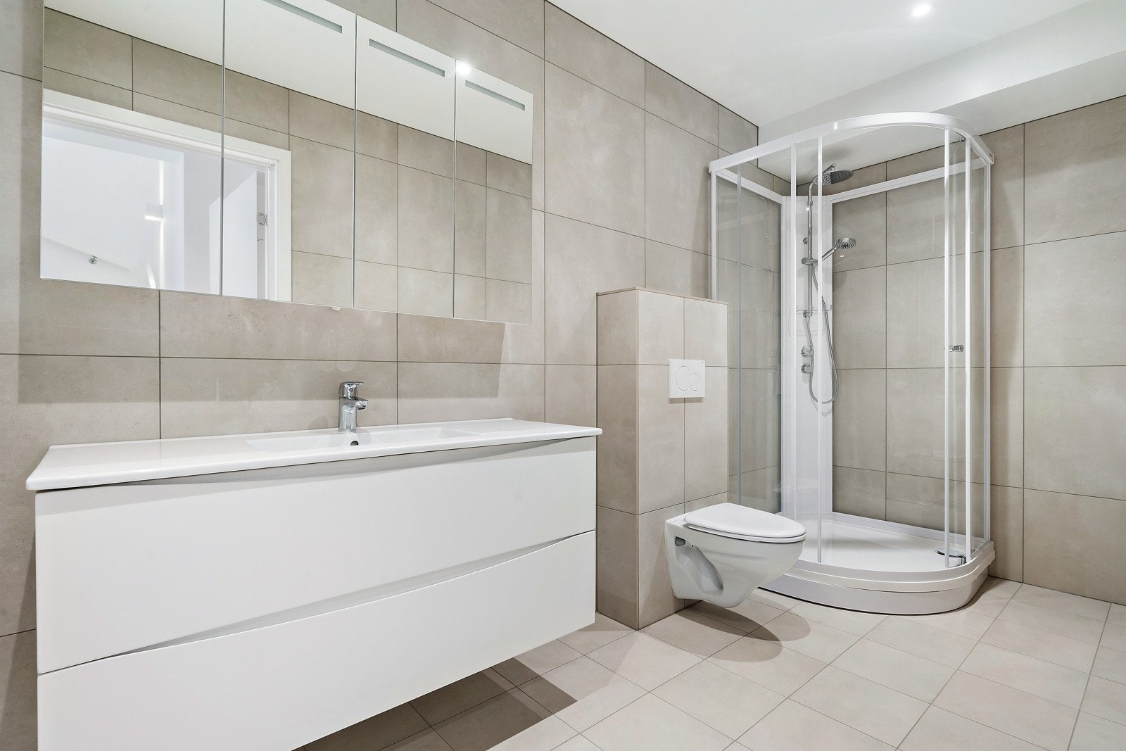 Delikat flislagt bad/wc med dusjkabinett og vegghengt wc | elektrisk varmekabler | tidsriktig fargevalg | storformat fliser Galleribilde