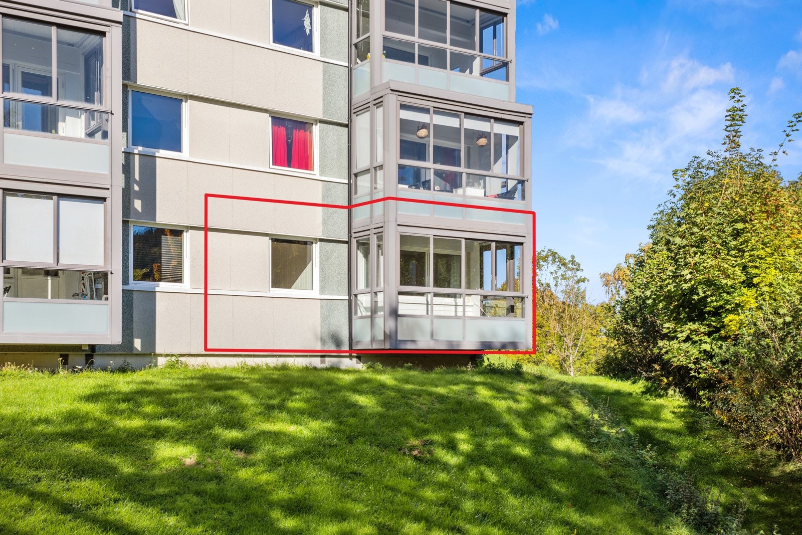 Boligen ligger pent opphøyd fra felles grøntareal som skjermer for innsyn. Galleribilde