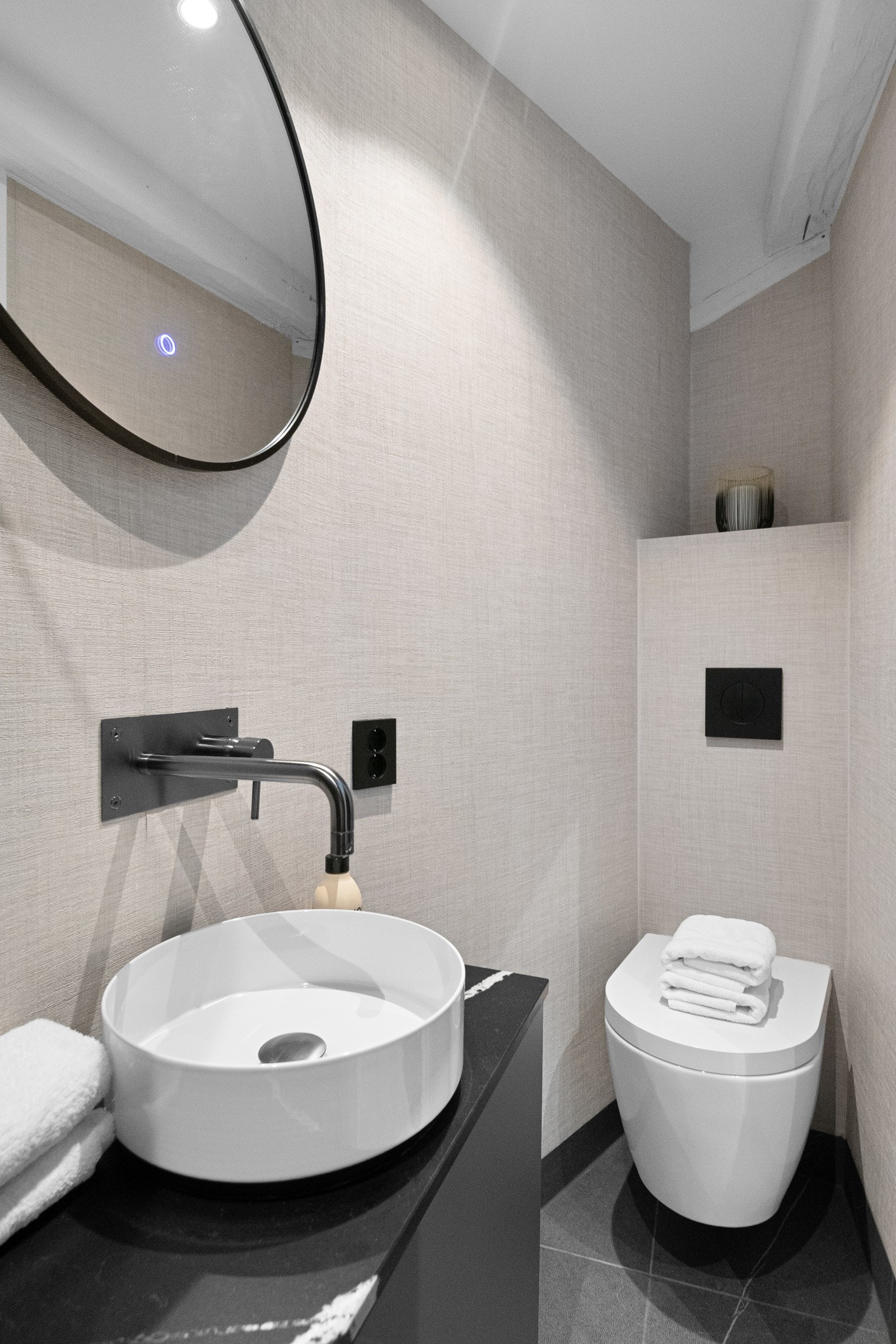 Baderommet er stilfullt innredet med dusj, servant med underskap og toalett Galleribilde