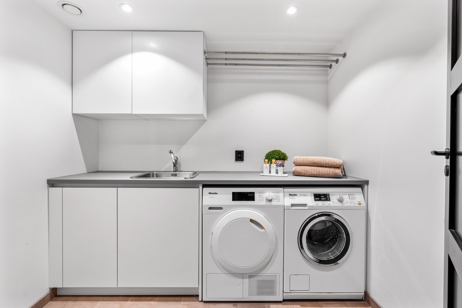 Vaskerommet er utstyrt med praktiske løsninger og har en gjennomgående god standard. Rommet er flislagt med varmekabler i gulvet, noe som bidrar til tørre og varme overflater. Galleribilde