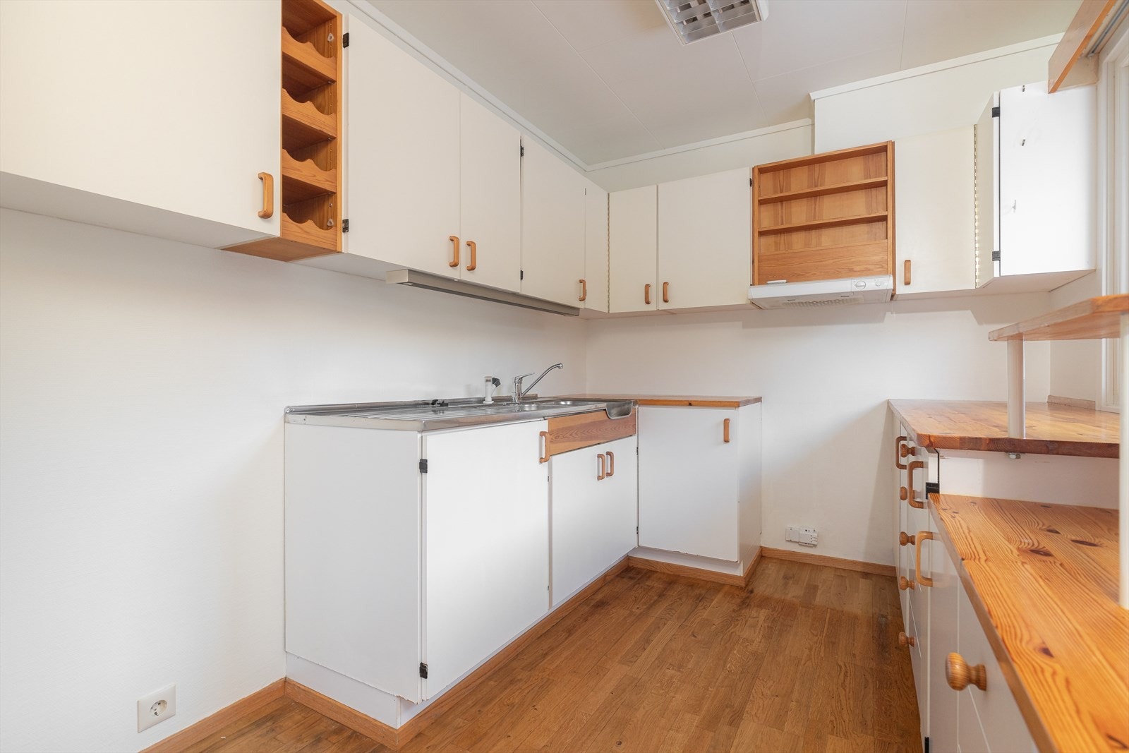 Det er benkebeslått oppvaskkum i rustfritt stål og plass for frittstående komfyr. Over kokesone er det kjøkkenventilator med avtrekk ut. Galleribilde