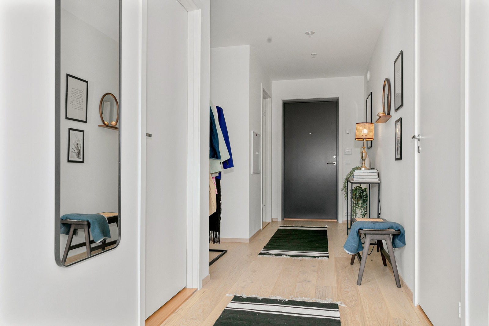 Boligen ønsker deg velkommen med en innbydende entré som kombinerer funksjonalitet og stil. Her finner du eikeparkett og hvitmalte vegger som gir et lyst og moderne uttrykk. Galleribilde