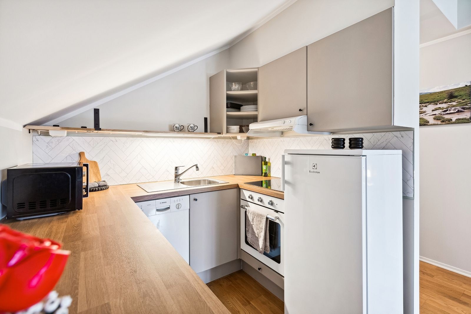 Kjøkken som inneholder alt man trenger av hvitevarer Galleribilde