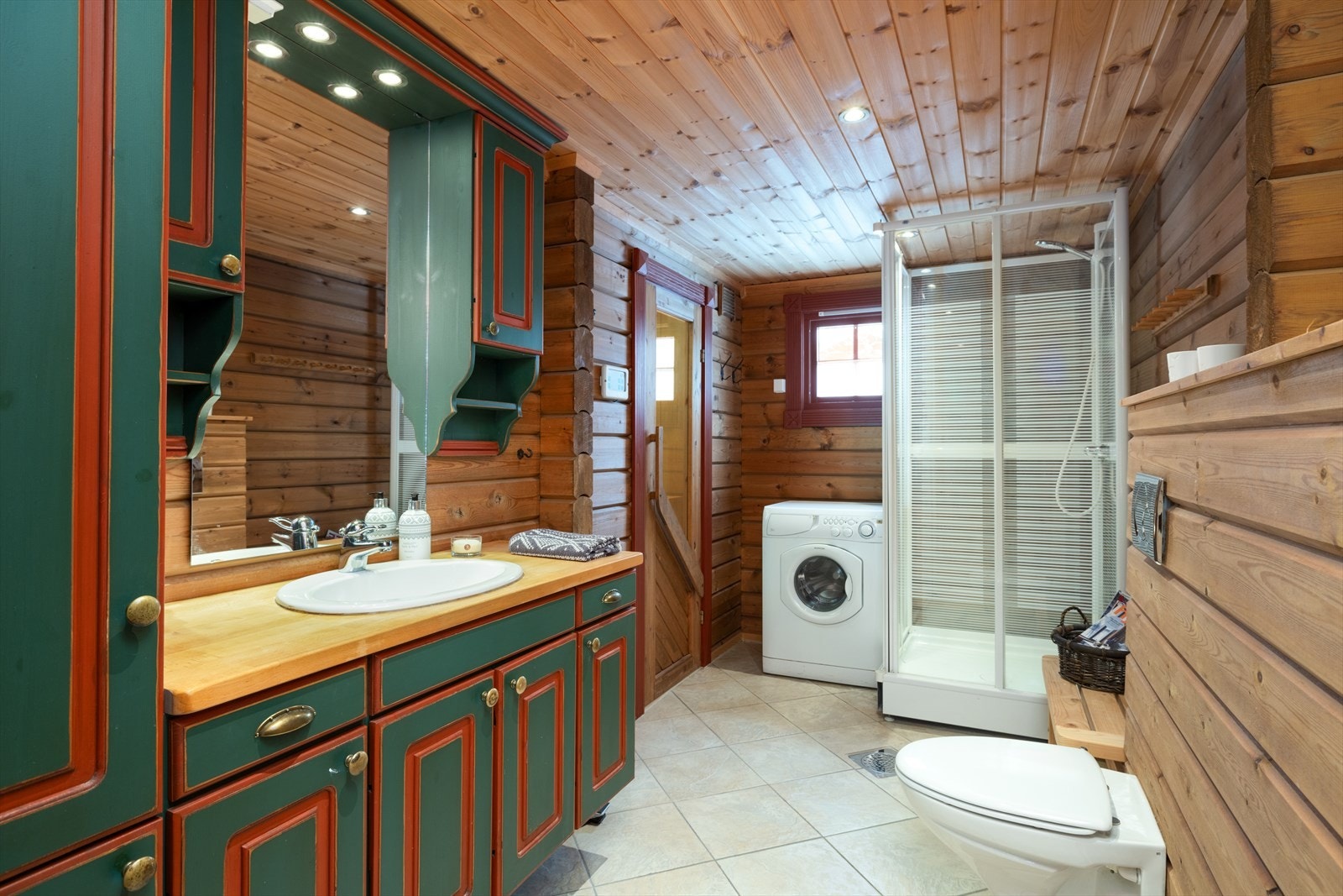 Fint bad innredet med servant på innredning, dusjkabinett og toalett. Galleribilde