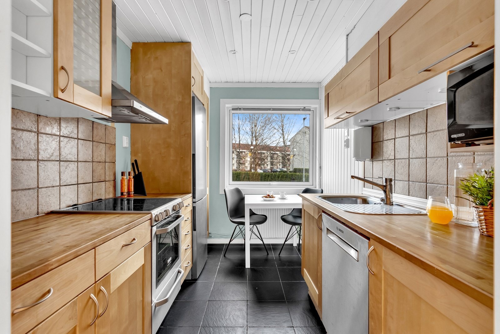 Funksjonelt og velholdt kjøkken med profilerte fronter og benkeplate i heltre. Galleribilde