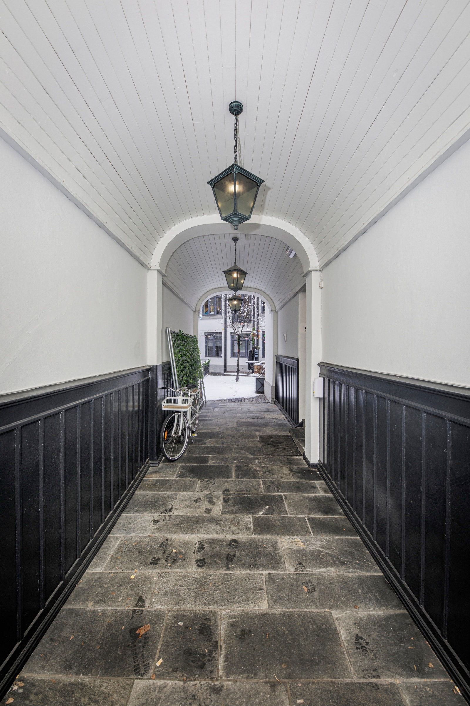 Pent inngangsparti til bygget og hyggelig bakgård. Galleribilde