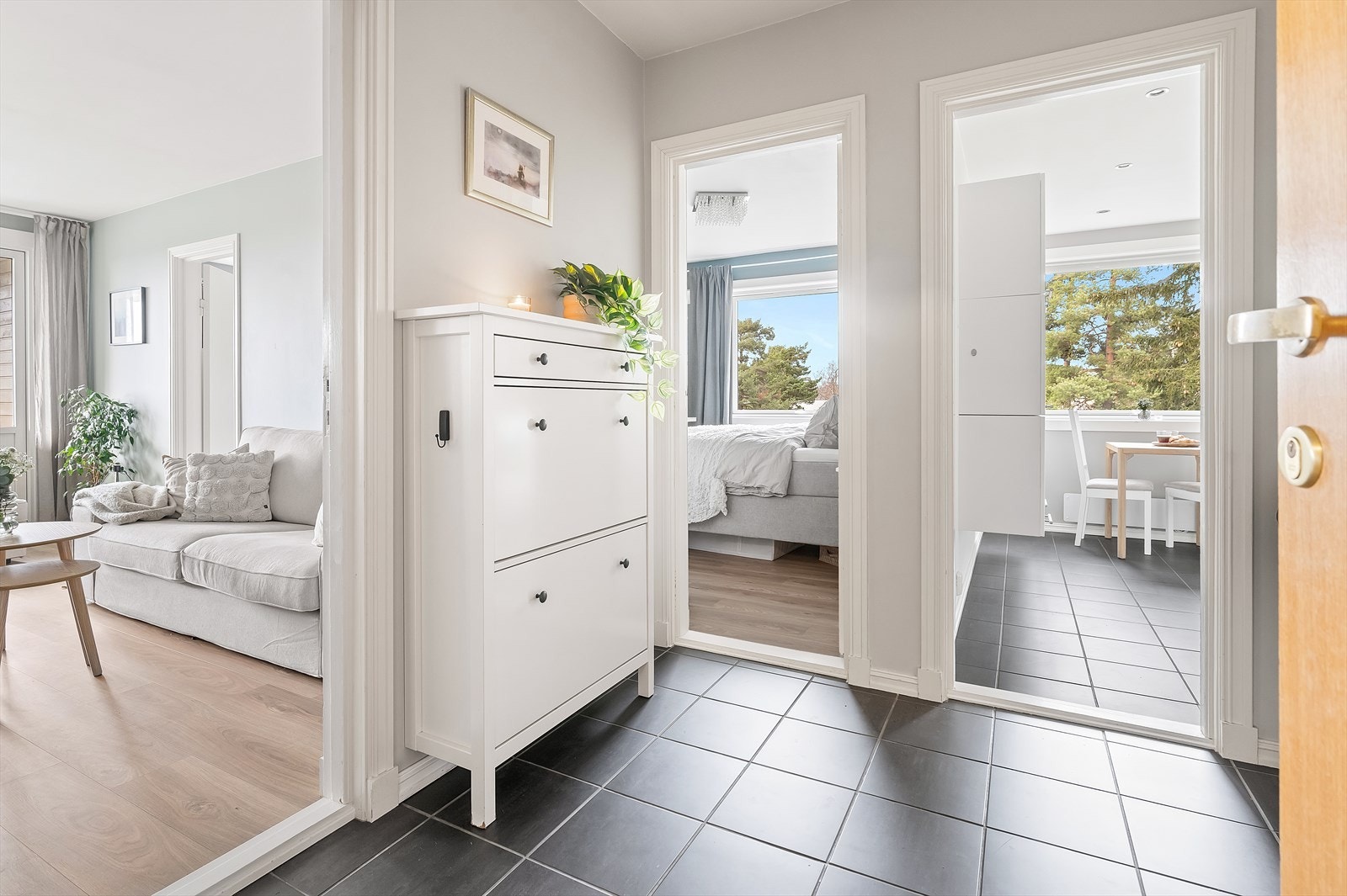 Den romslige entreen fungerer som et sentralt knutepunkt i boligen, med tilgang til alle rom (utenom soverom II). Galleribilde