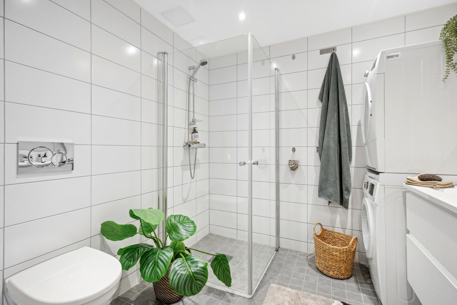 Videre er det dusj med innfellbare dører i herdet glass, veggfestet klosett med innebygget sisterne og opplegg/plass for vaskemaskin. Galleribilde