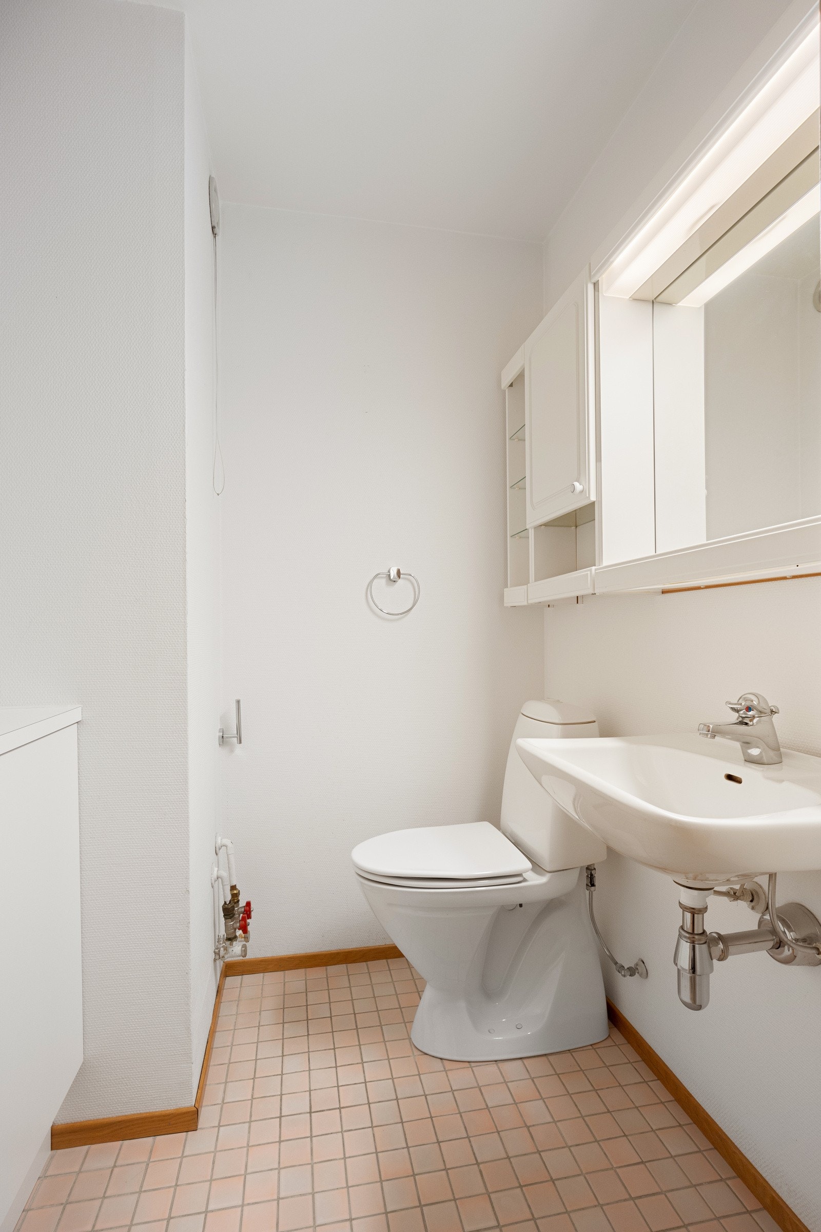 Vegg i vegg med badet finner man et praktisk gjestetoalett med flislagt gulv. Galleribilde