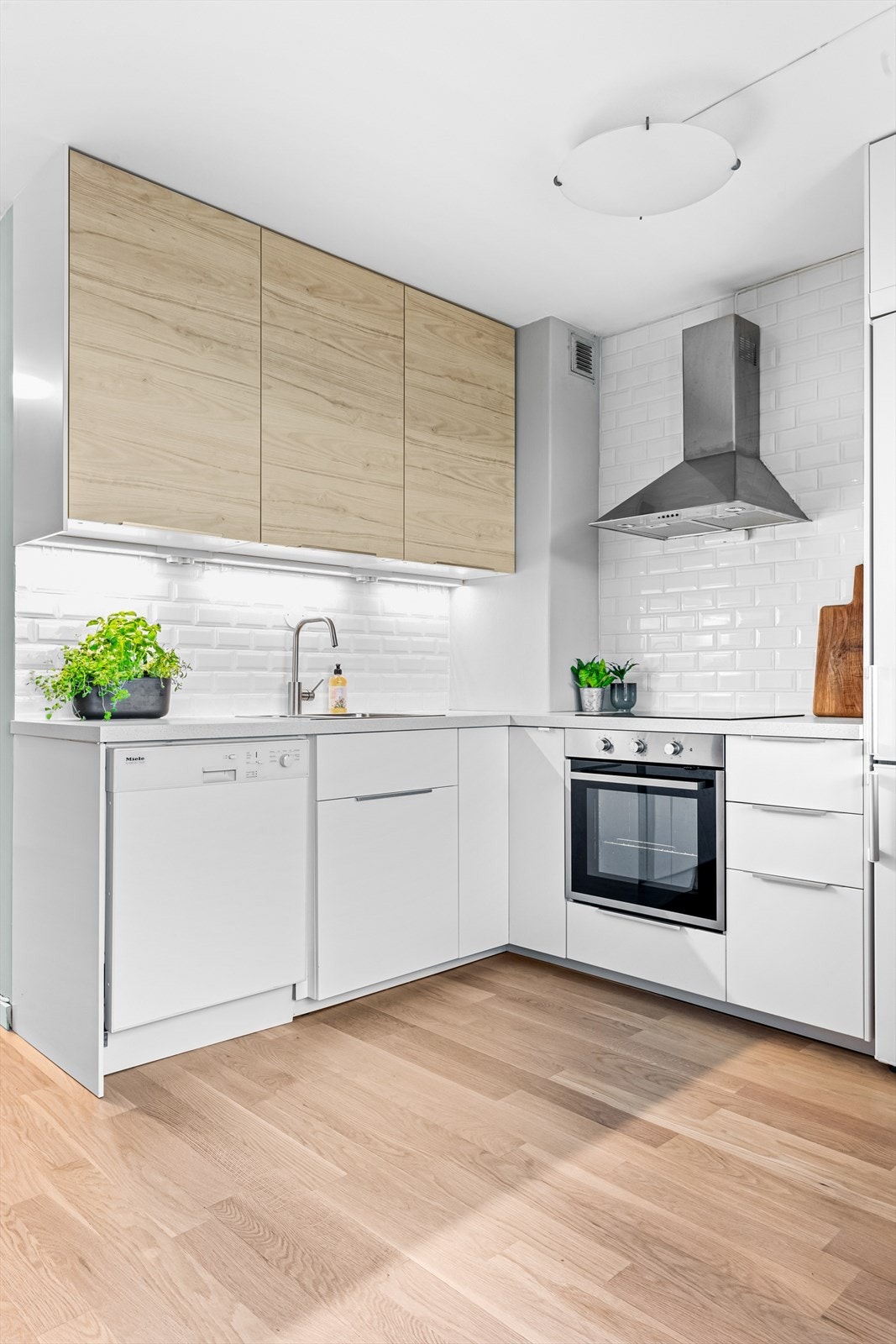 Innredningen er bestående av glatte fronter og foliert benkeplate. Flislagt vegg over benkeplate. Videre er kjøkkenet utstyrt med platetopp, kum med ettgreps blandebatteri, ventilator, kjøl/fryseskap, ovn og oppvaskmaskin. Galleribilde