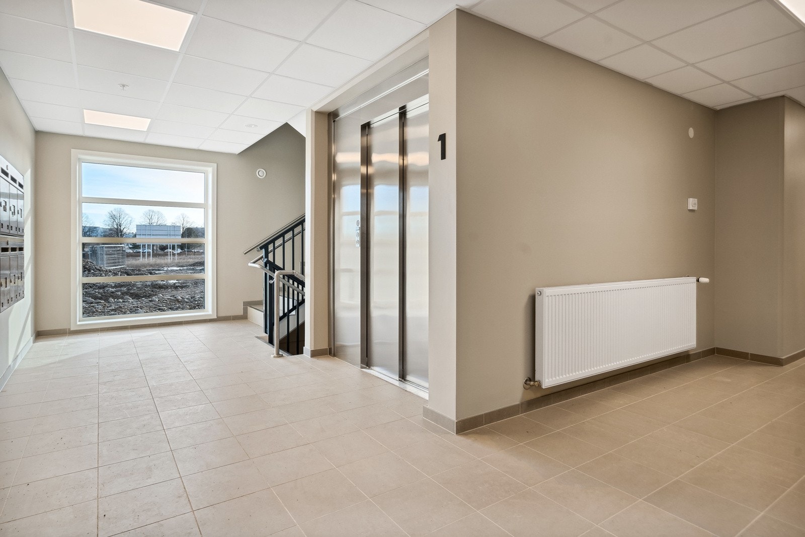 Flott romslig felles gang med heis og trappeadkomst mellom etasjene Galleribilde