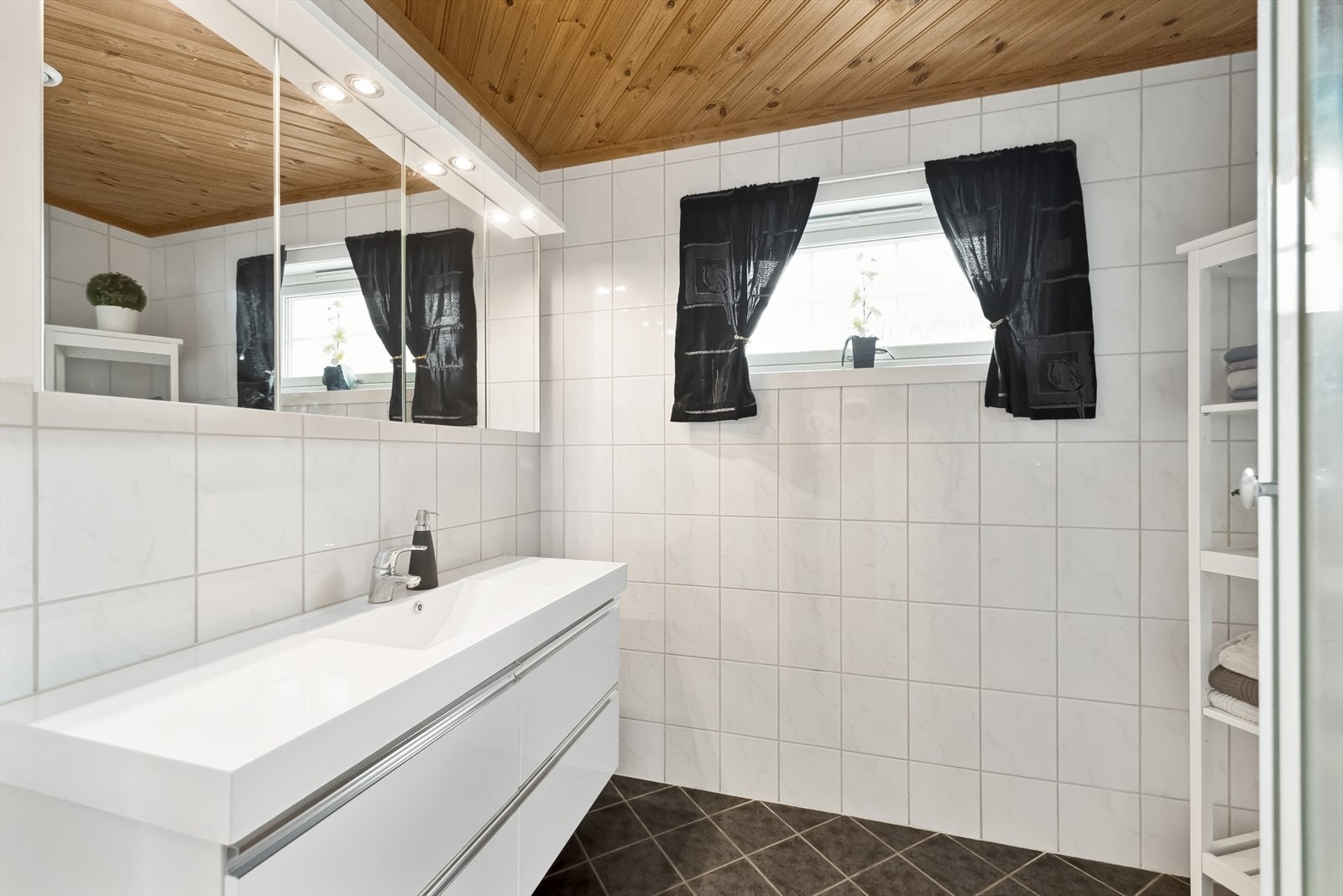 Flislagt bad med gulvvarme. Badet er innredet med servant og dusjkabinett. Galleribilde