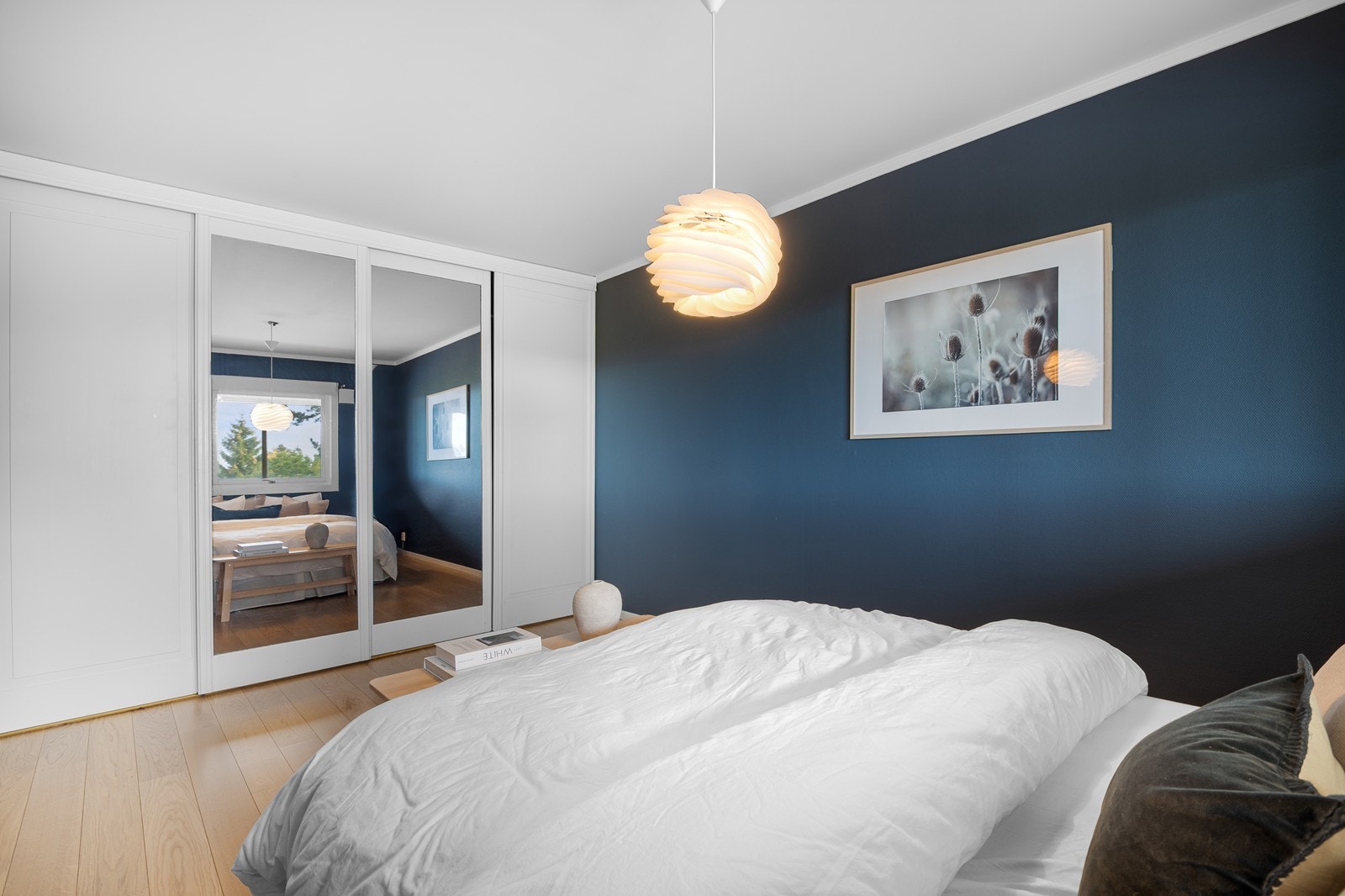 En stor skyvedørsgarderobe strekker seg fra vegg til vegg. Rommet har parkett med gulvvarme og vegger er malt i en nydelig blåfarge. Galleribilde