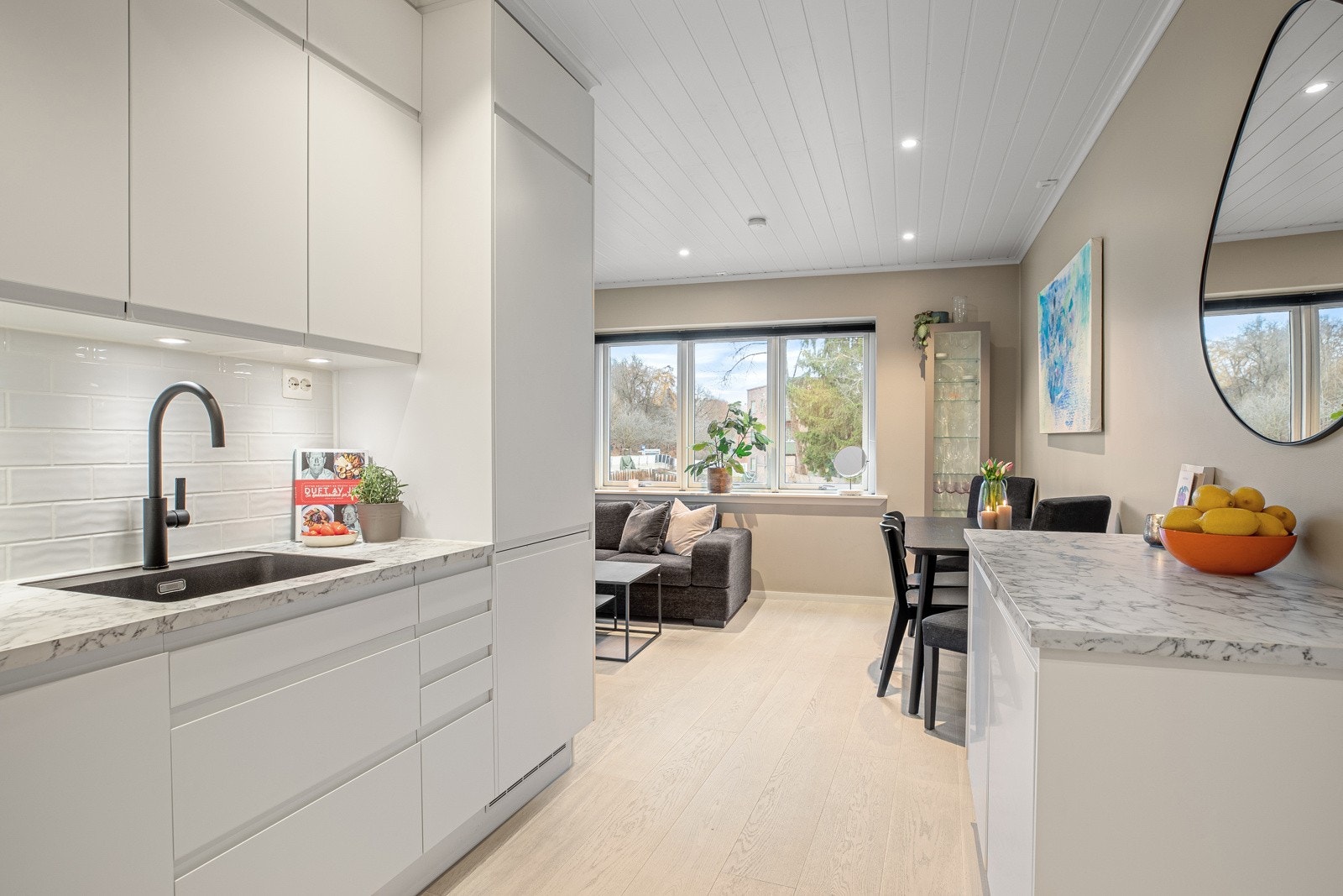 Lys laminat benkeplate med planlimt sort komposittvask og ett-greps armatur i sort Galleribilde