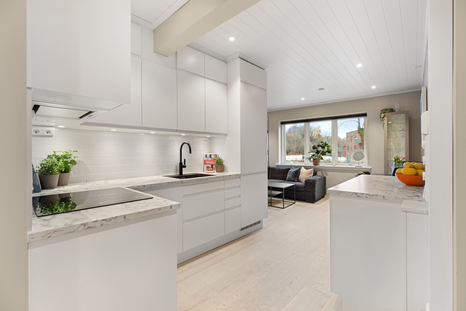 Lekkert kjøkken i delvis åpen løsning mot stuen Galleribilde