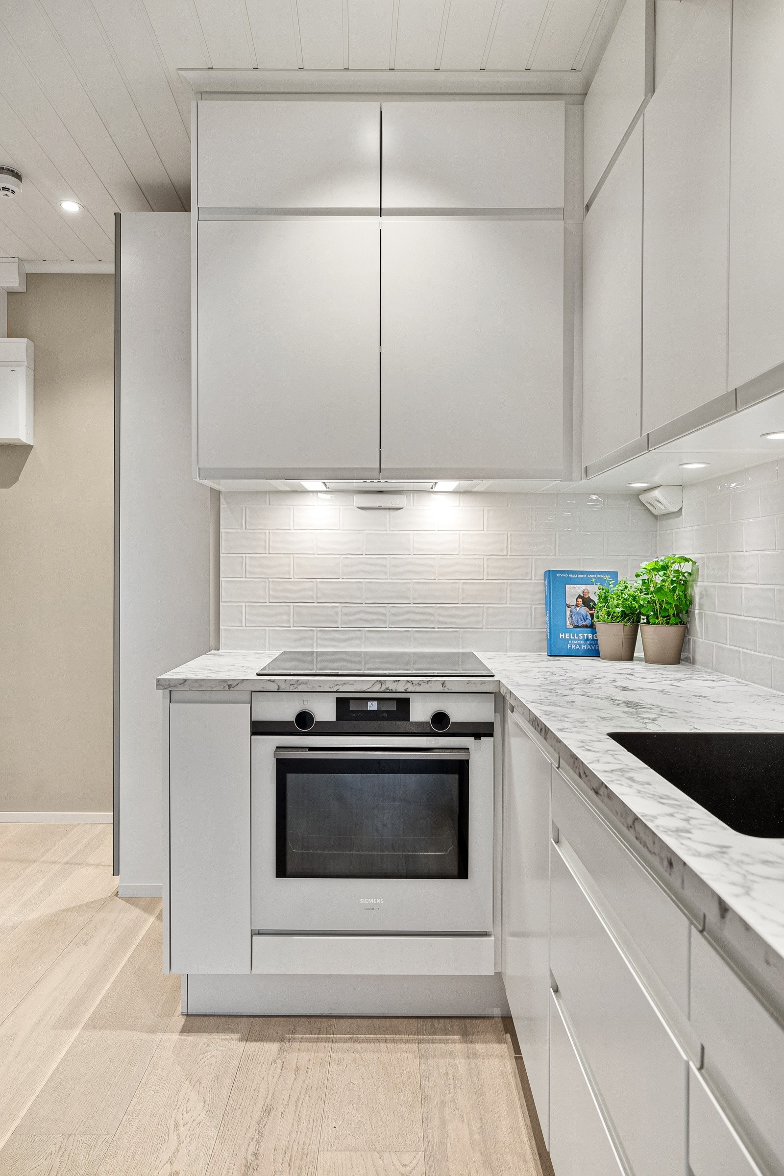 Integrerte hvitevarer fra Siemens som oppvaskmaskin, kjøl/frys, stekeovn, platetopp og avtrekksvifte samt opplegg for vaskemaskin Galleribilde