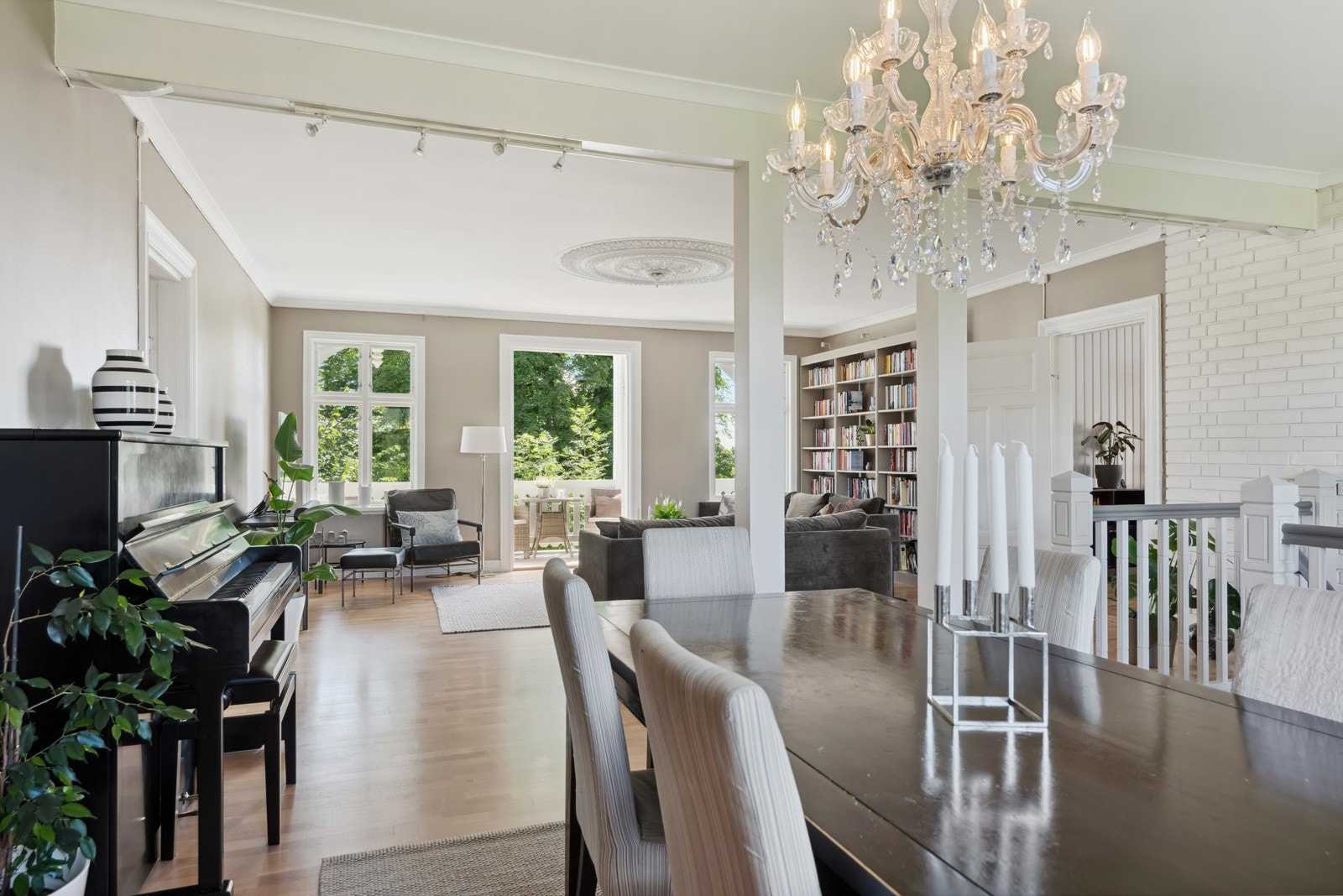 God takhøyde med rosett og lun stemning kjennetegner stuen som har god plass til både sofagruppe og spisestue. Galleribilde