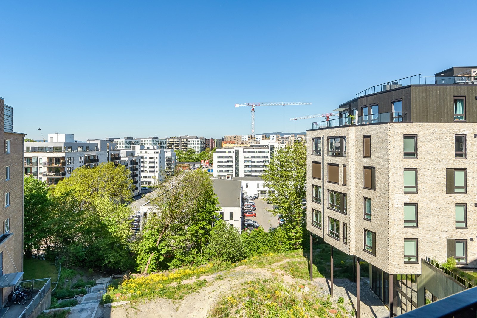 Utsiikt fra balkongen, det er planlagt opparbeiding av gangvei ned mot Ensjø sentrum slik at det vil bli enda kortere å komme seg til T-banen og butikkene. Galleribilde