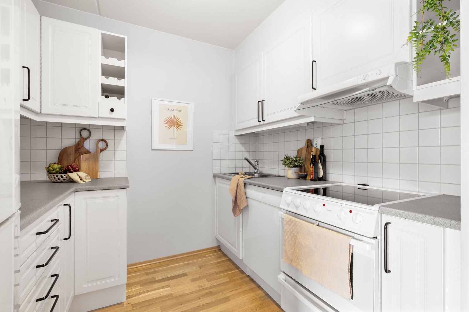 Kjøkkeninnredning med profilerte lyse fronter og benkeplater av laminat Galleribilde