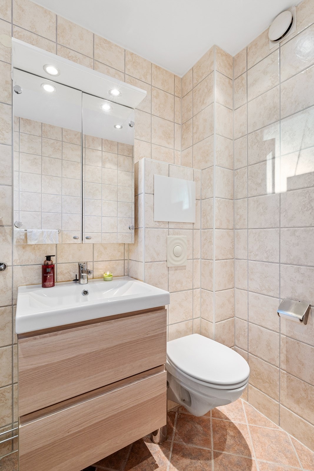 Det er porselen servant med ettgreps servantbatteri og servantskap. Speilskap med overliggende lyslist over servant. Det er veggklosett. Galleribilde