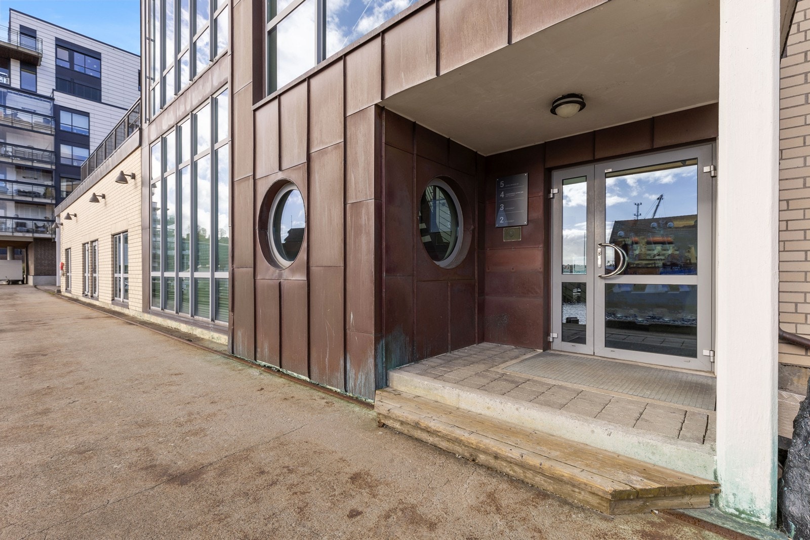 Inngangsparti på gateplan. Heis i bygget. Galleribilde