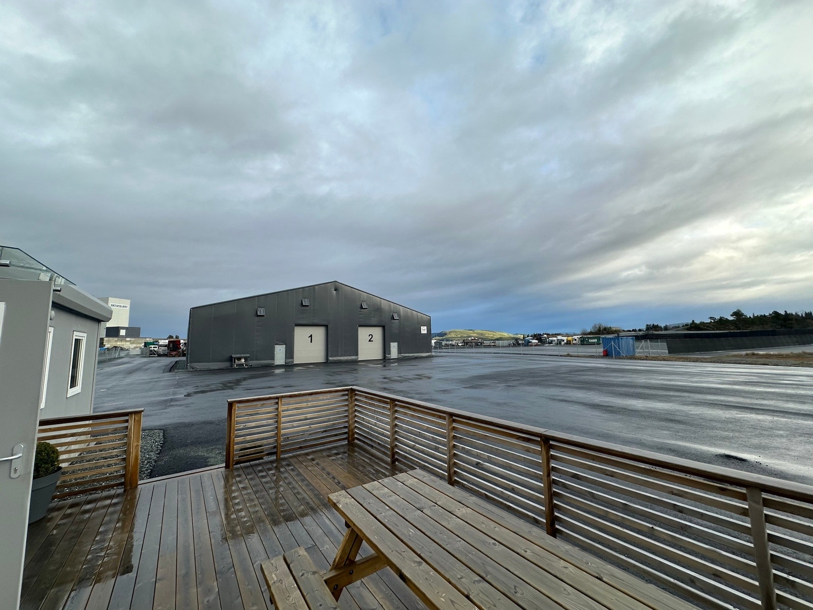 Terasse med uteplass. Ellbillader. Store asfalterte flater på eiendommen. Galleribilde