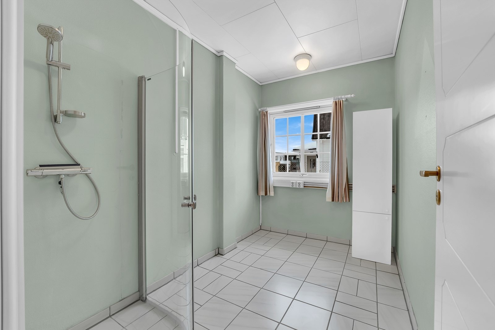Garderobe i god størrelse innredet med dusj og skap. Flislagt gulv med varmekabler. Galleribilde