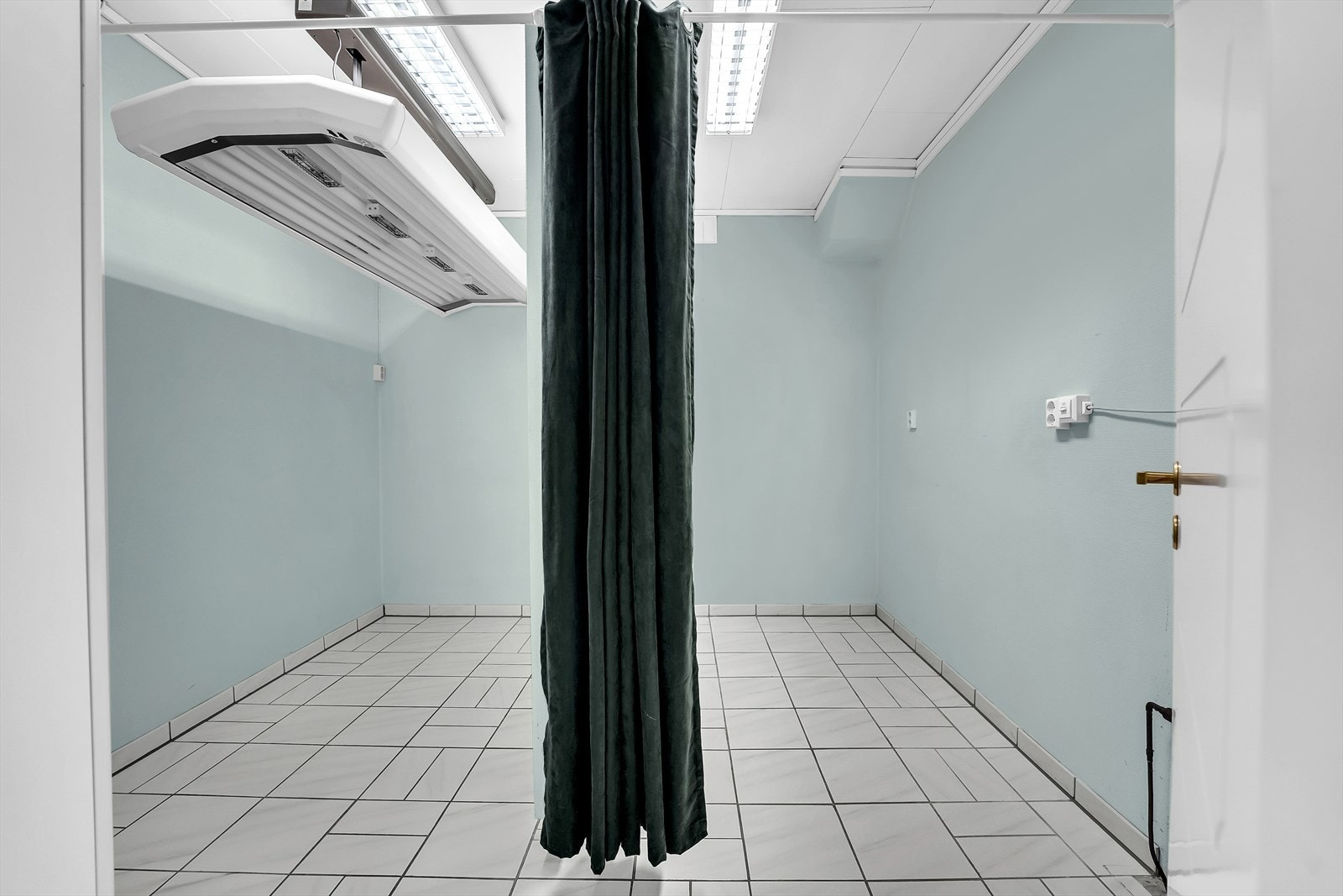Behandlingsrom 2 med skillevegg i lyse farger. Flislagt gulv. Varmekabler i gulv. Galleribilde
