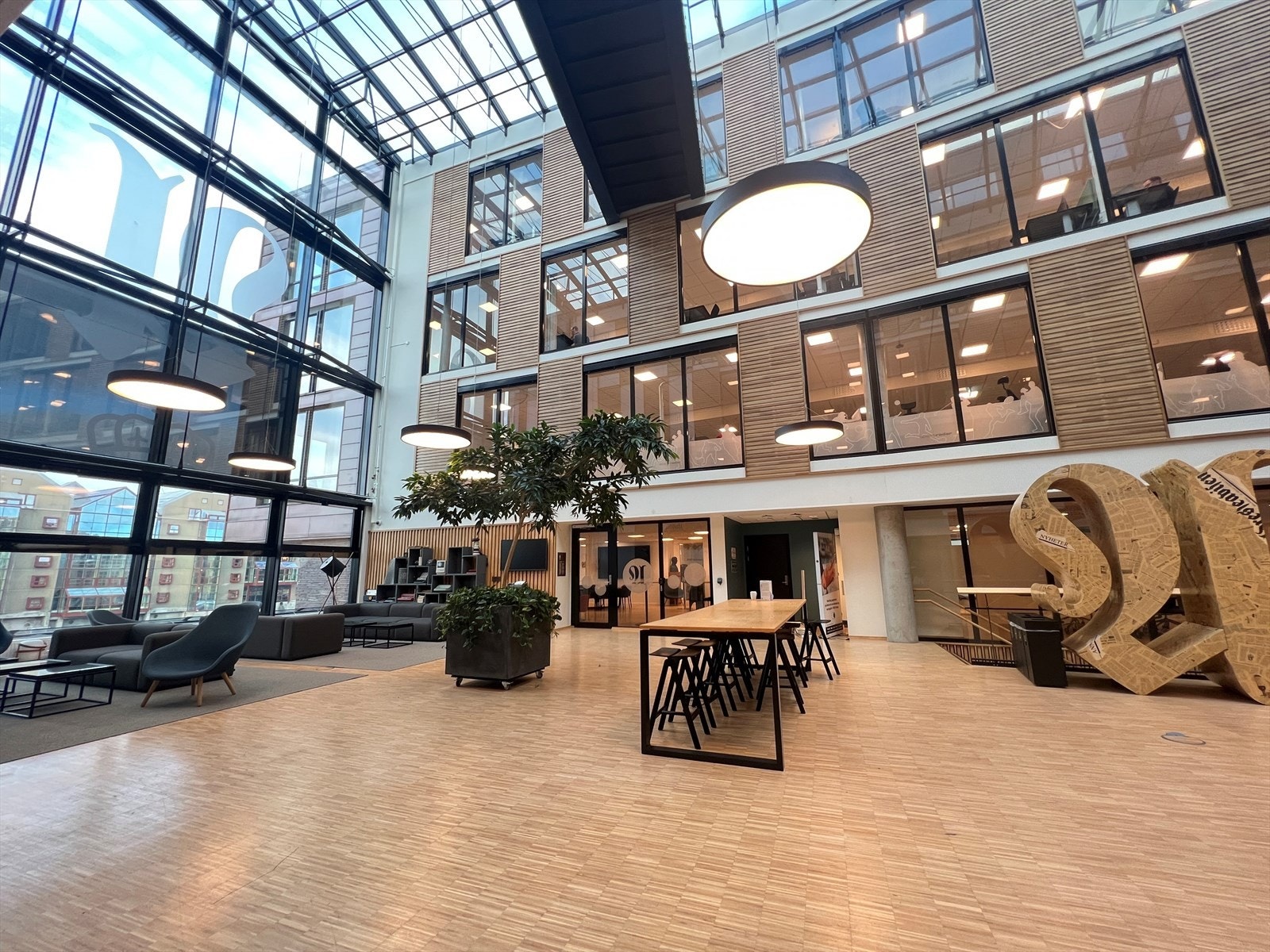 Fellesareal i 2.etasje med flere sittegrupper og utsikt mot Nidelven. Galleribilde