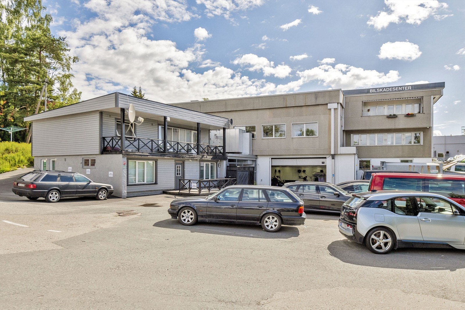 Inngang boligbygg samt kjøreport til lakkverksted i underetasjen til næringsdelen. Galleribilde