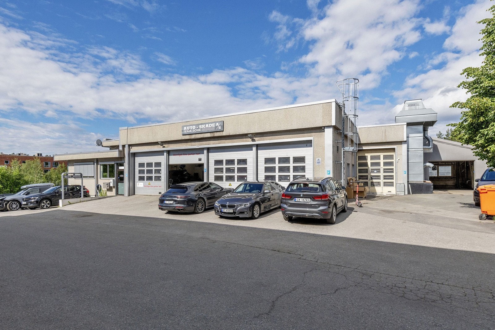 Innkjøring til verksted via 5 stk. kjøreporter og 1 stk. kjøreport på baksiden av bygget til lakkverksted i underetasjen. Galleribilde