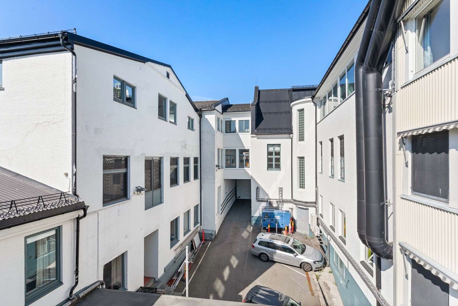 Bakgården med 3 parkeringsplasser. Galleribilde