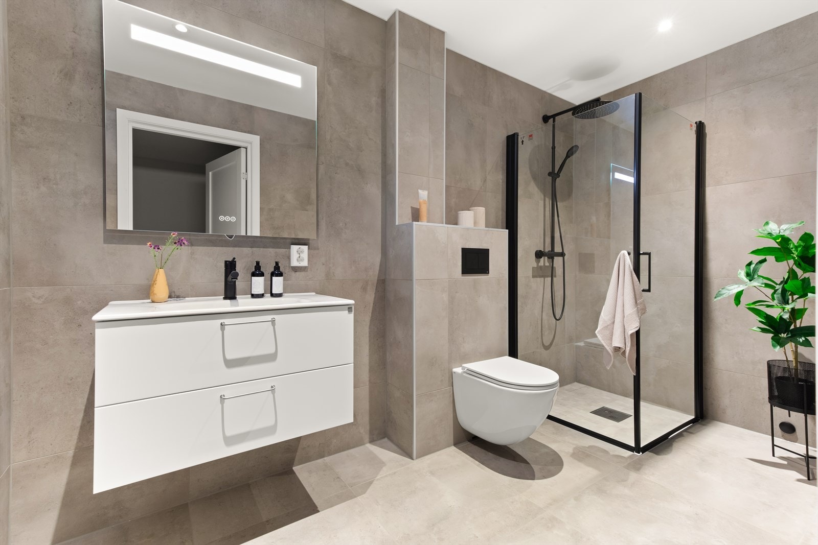 Boligen har to flotte bad og eget vaskerom. Badet i tredje etasje har flislagte overflater, varme i gulvet og LED-spotter i himlingen. Galleribilde