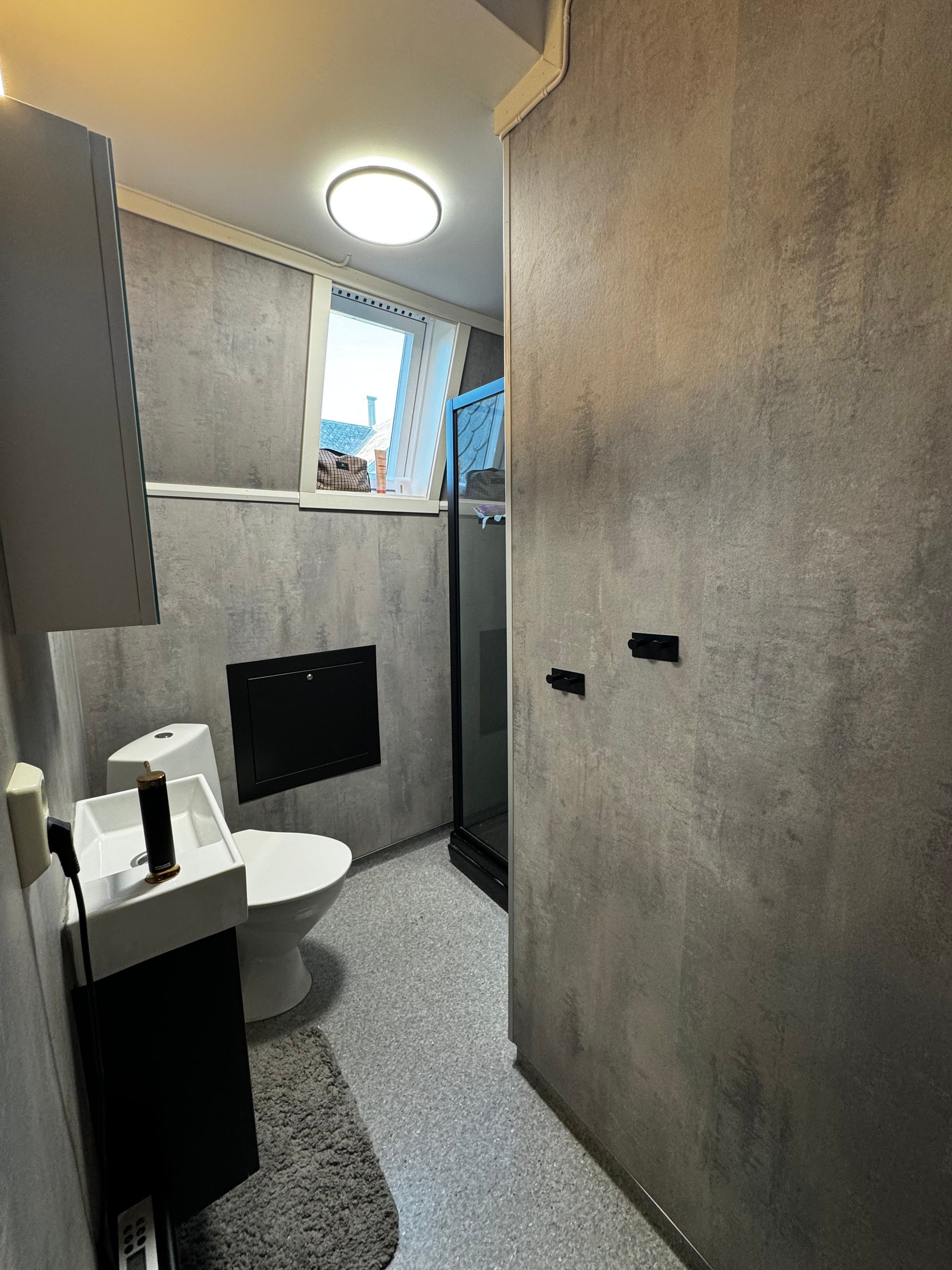 Bad med nye baderomsplater, baderomsinnredning og sort dusjkabinett Galleribilde