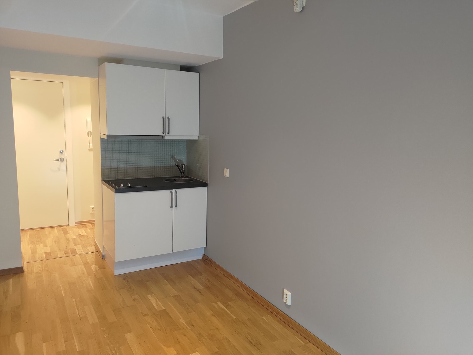 Kjøkkenløsning med kjøkkeninnredning med hvite fronter i høyglans og benkeplate av laminat. Galleribilde