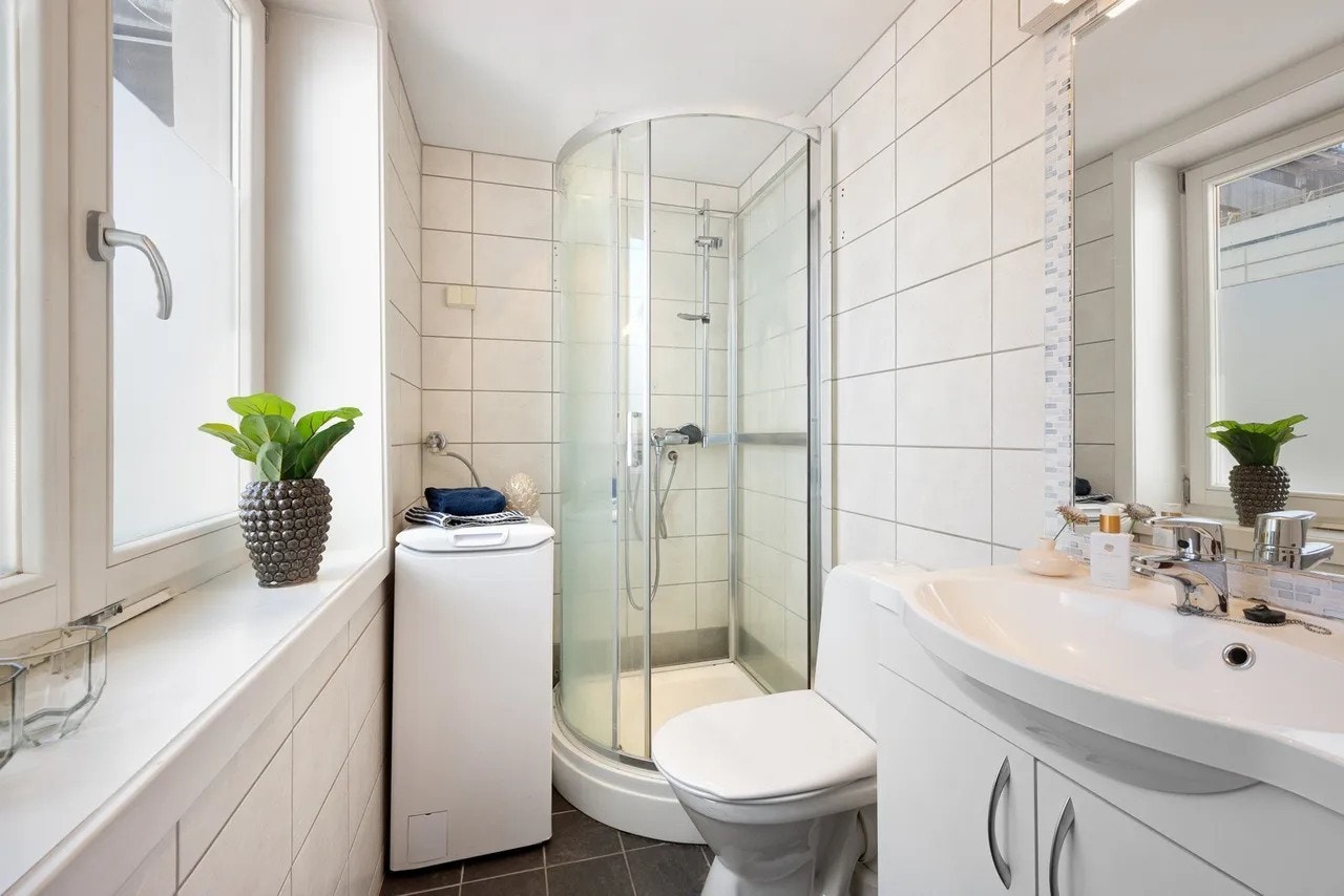 Pent bad med dusjkabinett og opplegg for vaskemaskin. Galleribilde